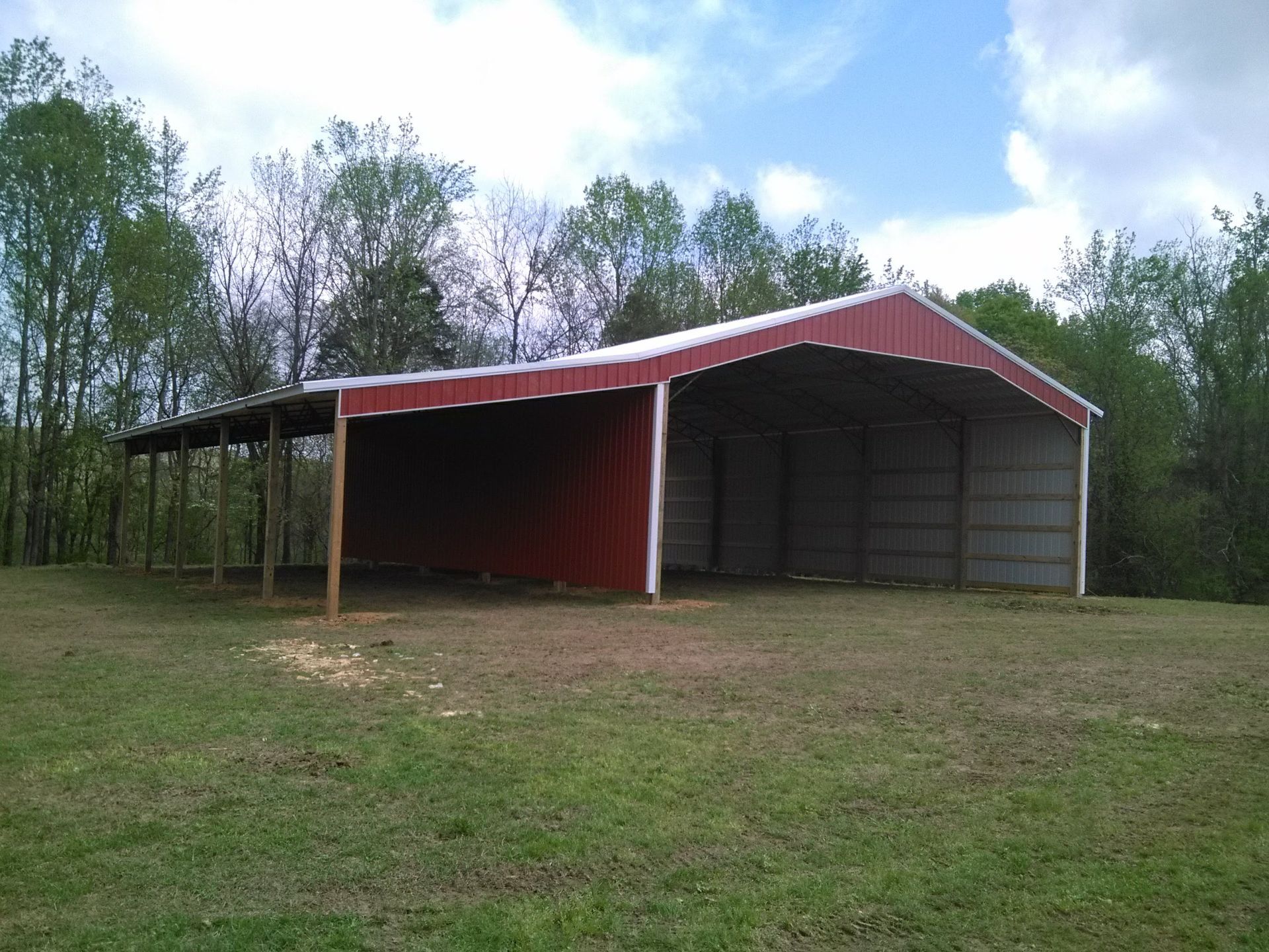 A red barn is sitting in the middle of a grassy field