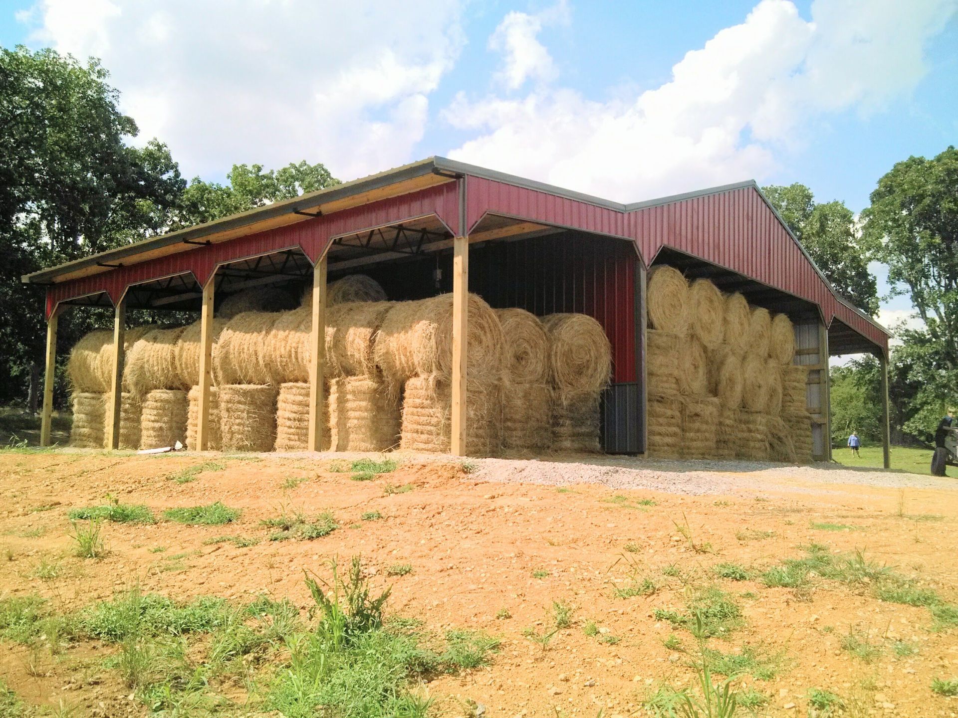 A barn filled with hay bales on a sunny day