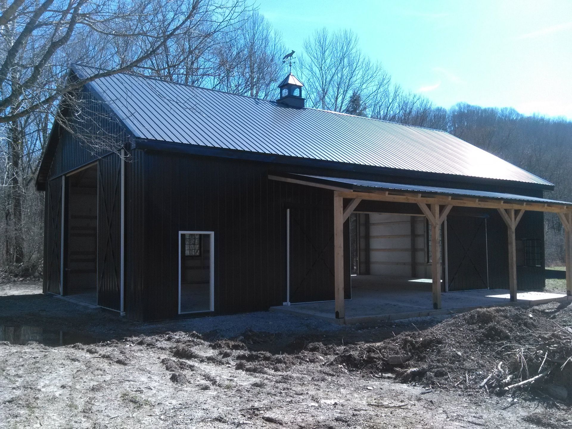 A large black building with a wooden porch on the side