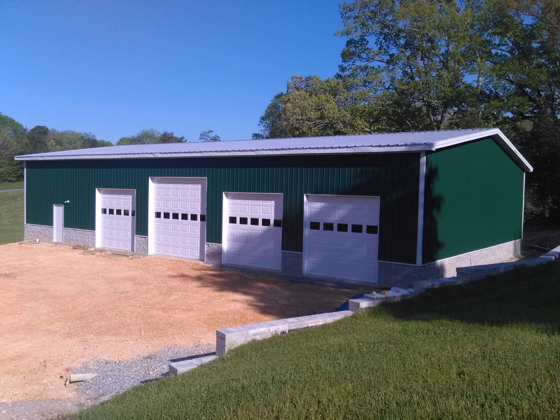 A large green building with white garage doors