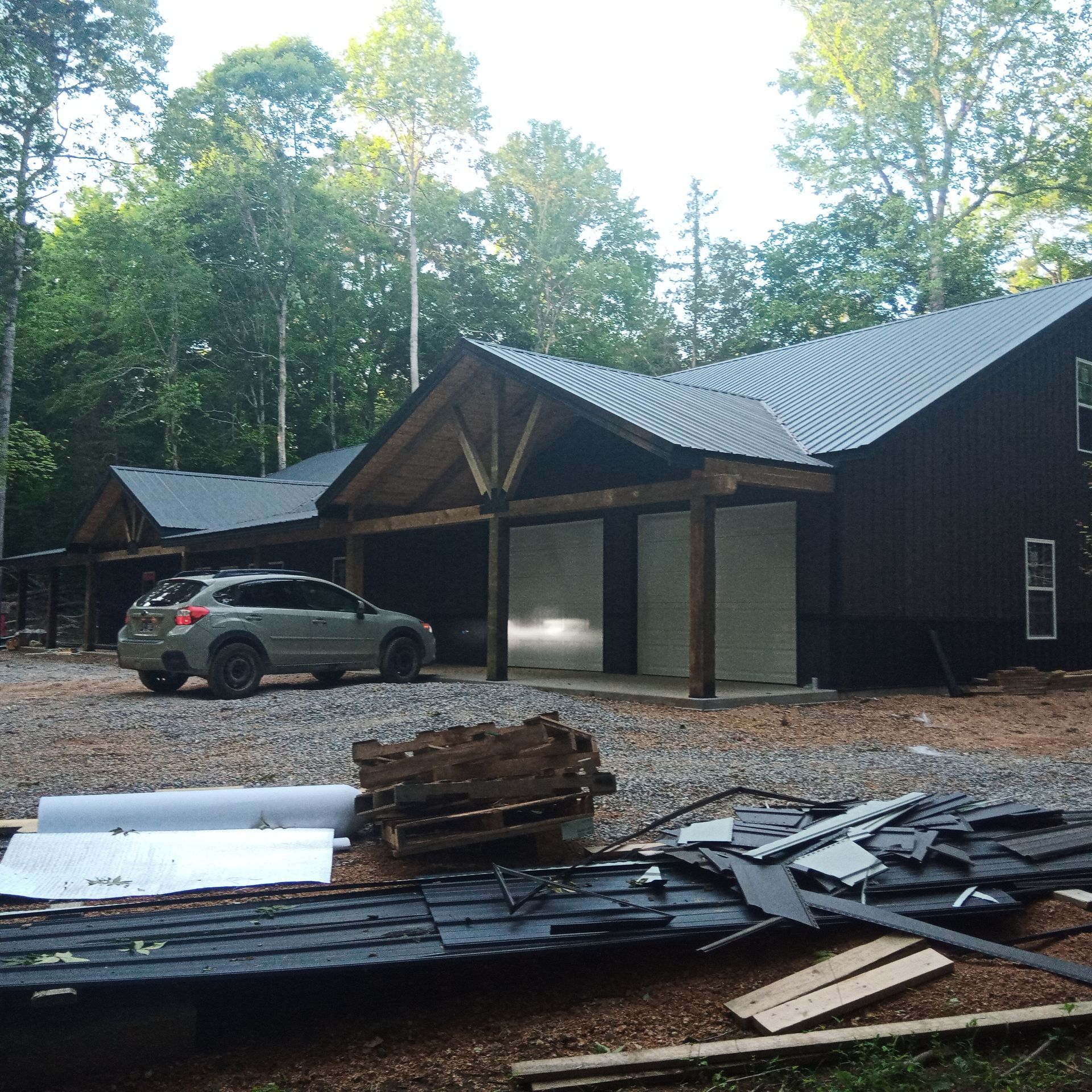 A car is parked in front of a house that is under construction