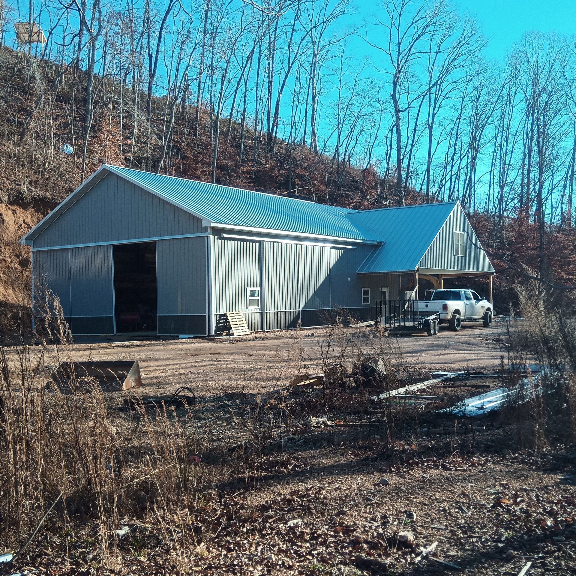 A truck is parked in front of a building with a metal roof