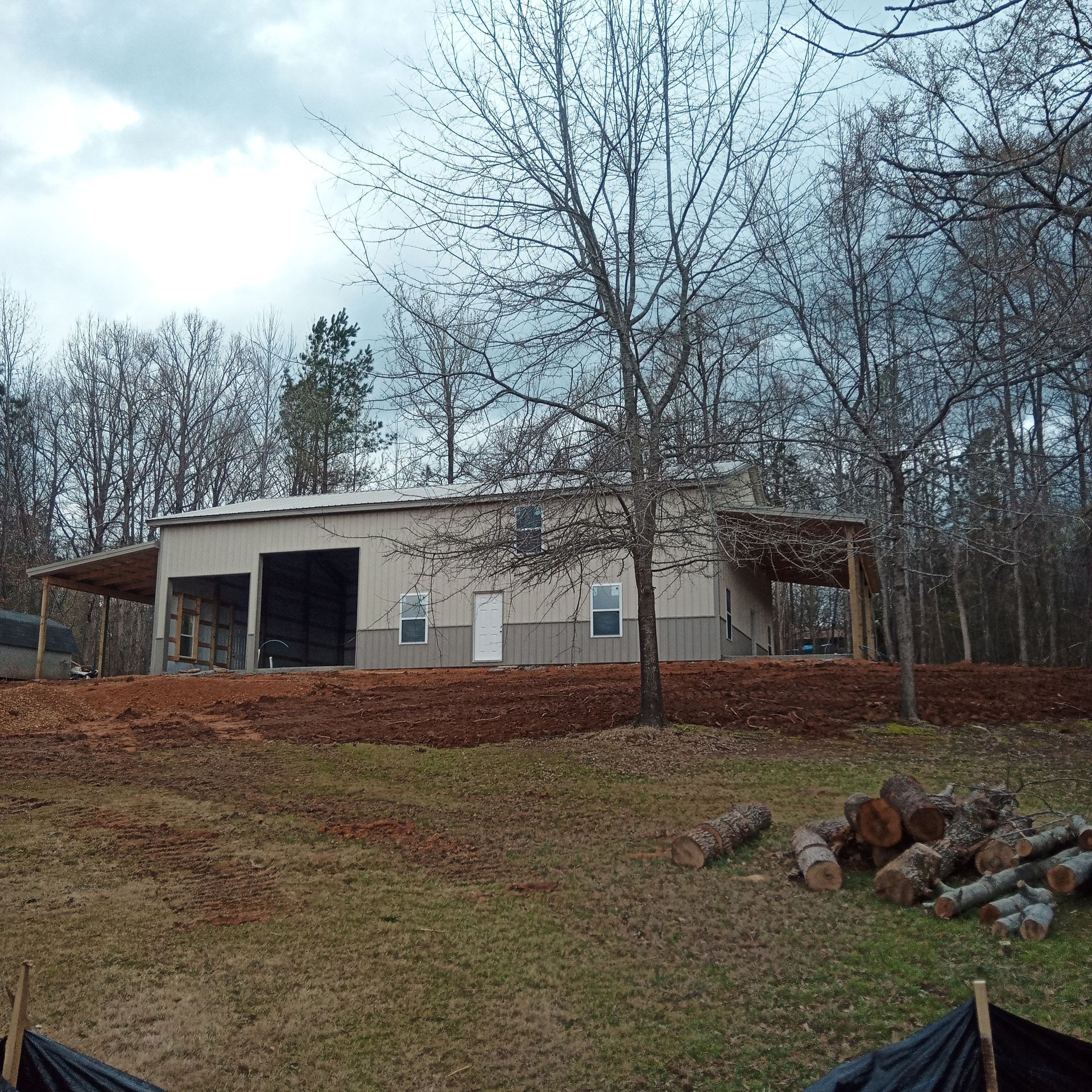 A large white building is sitting on top of a grassy hill