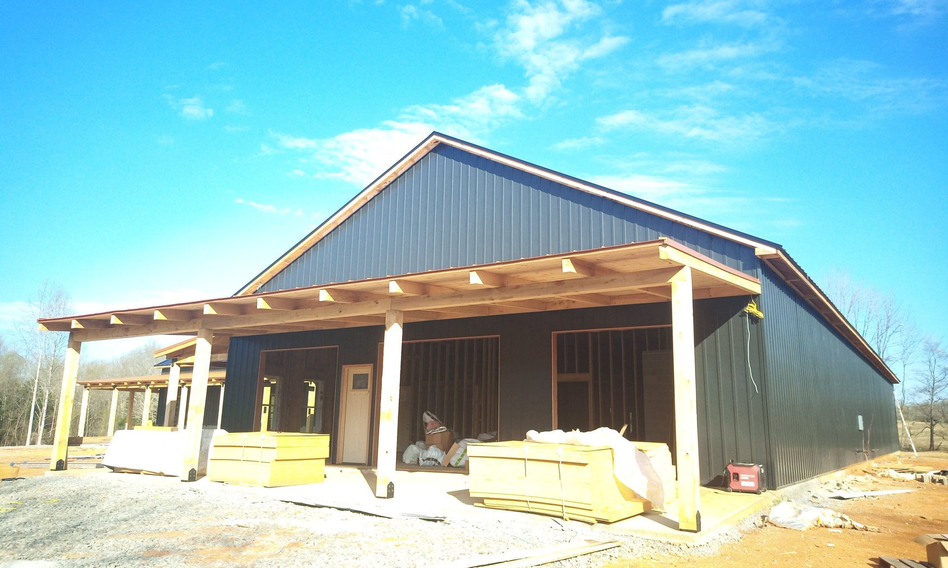 A building under construction with a porch and a blue sky in the background