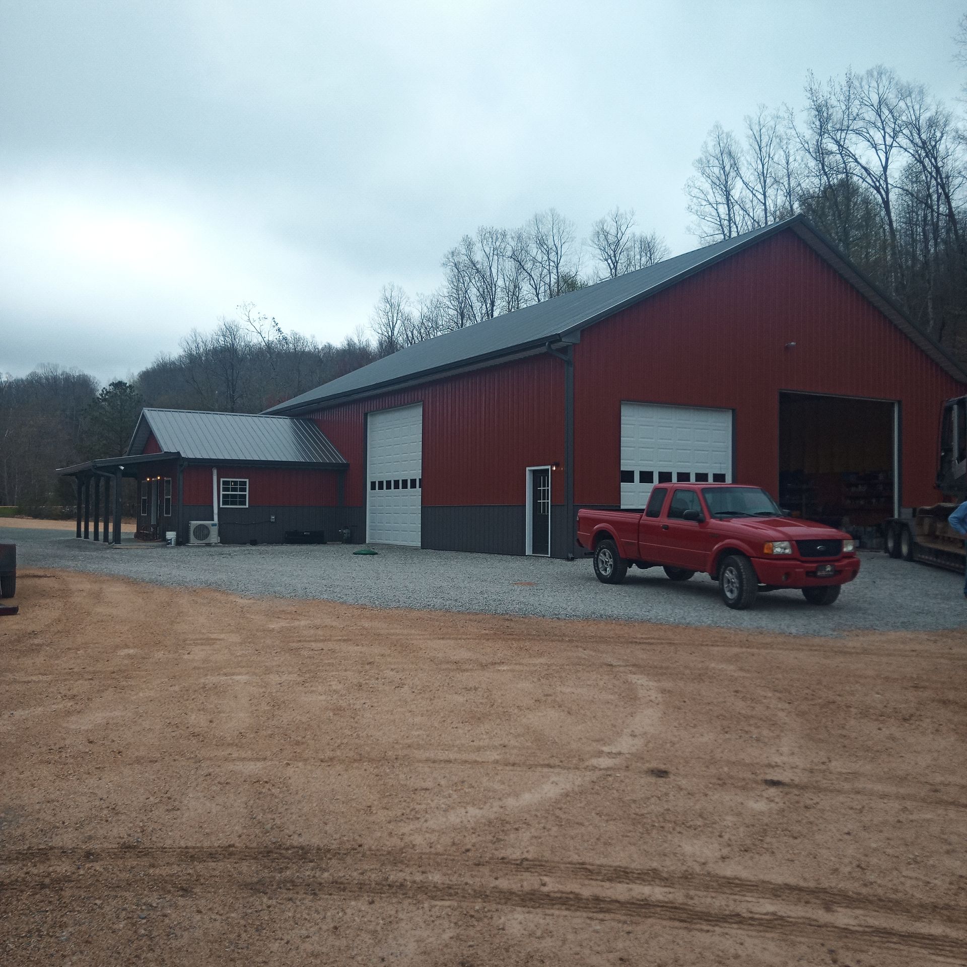A red truck is parked in front of a red building