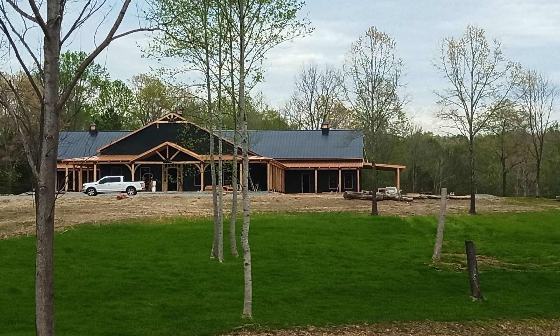 A white truck is parked in front of a house under construction