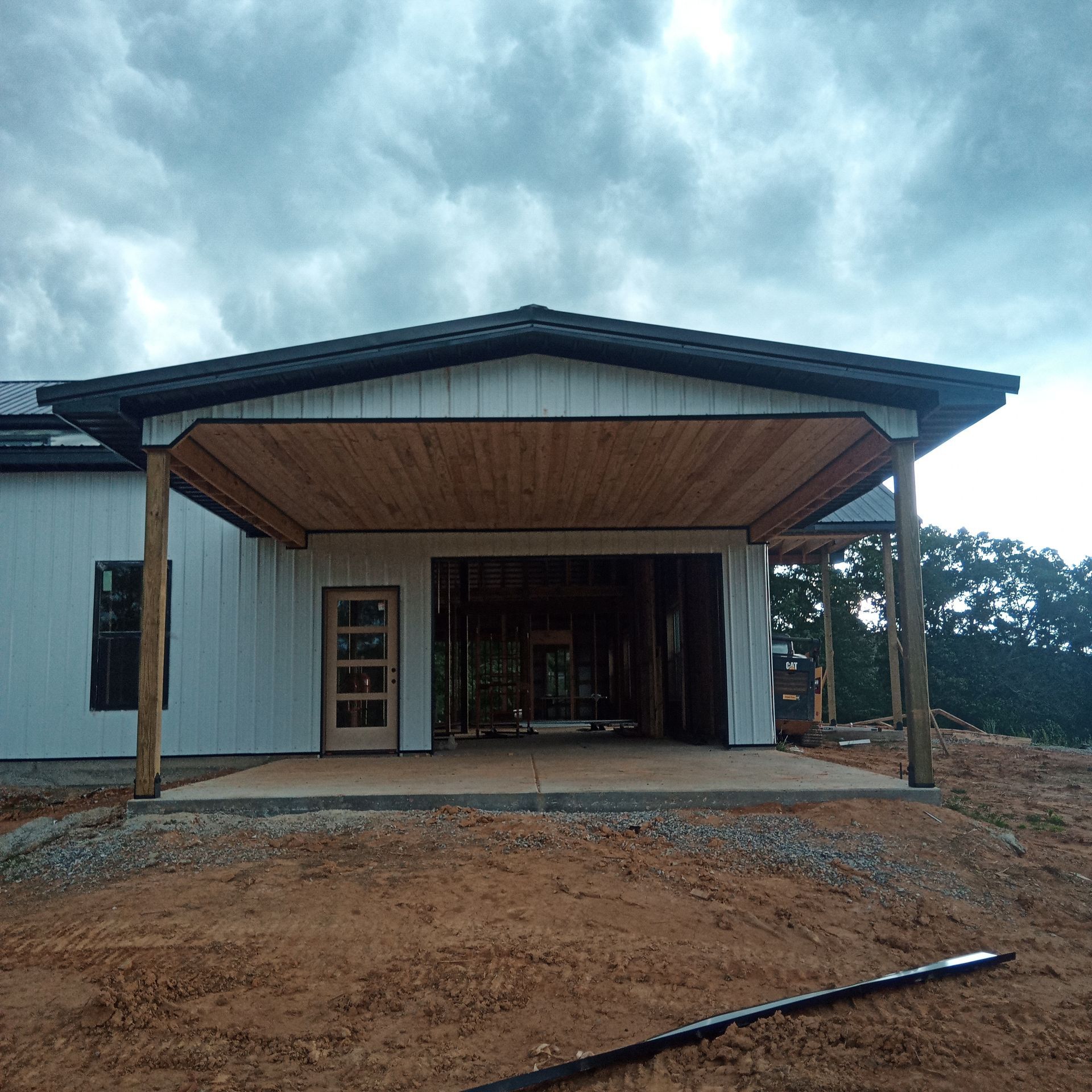 A white house with a wooden porch and a cloudy sky in the background