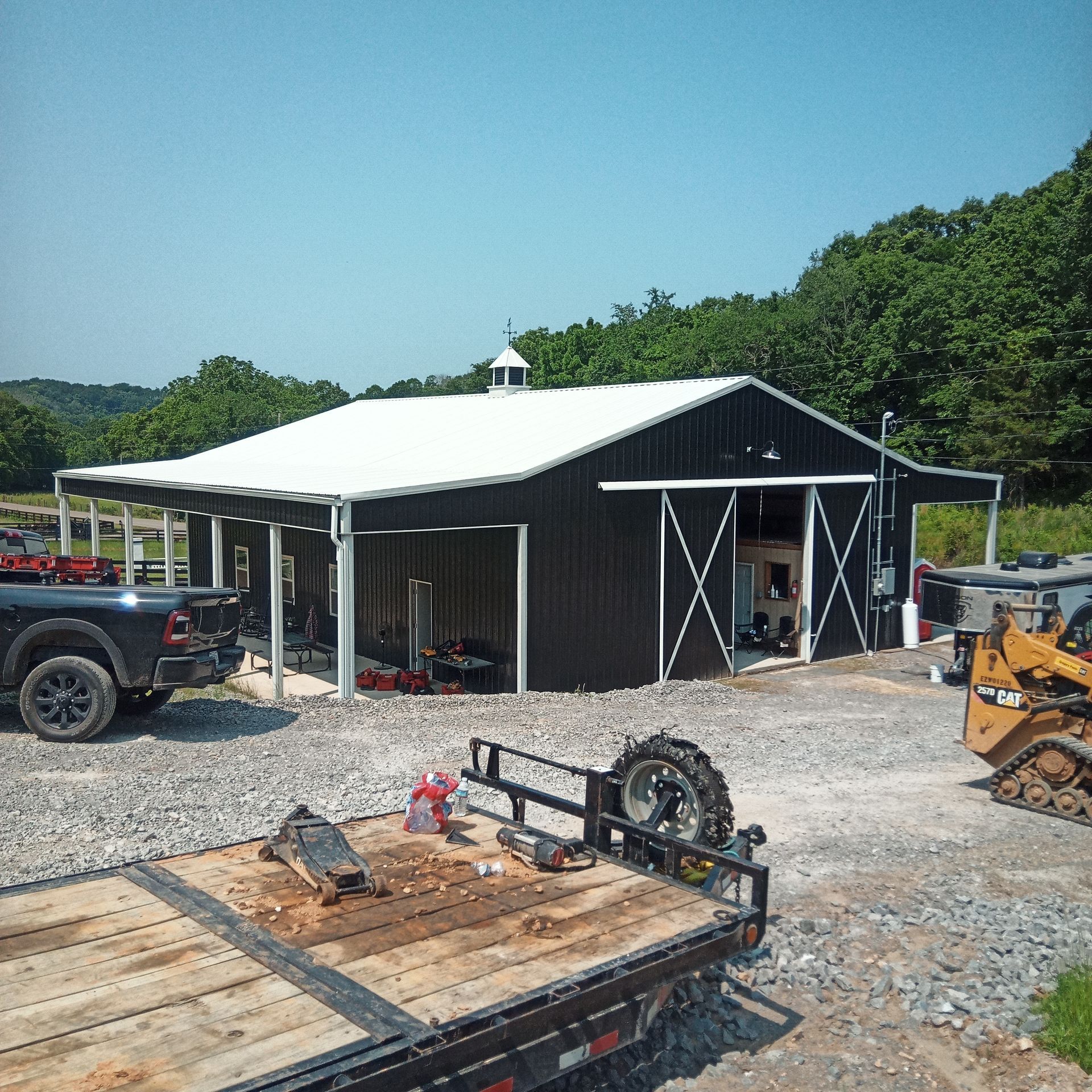 A truck is parked in front of a black barn