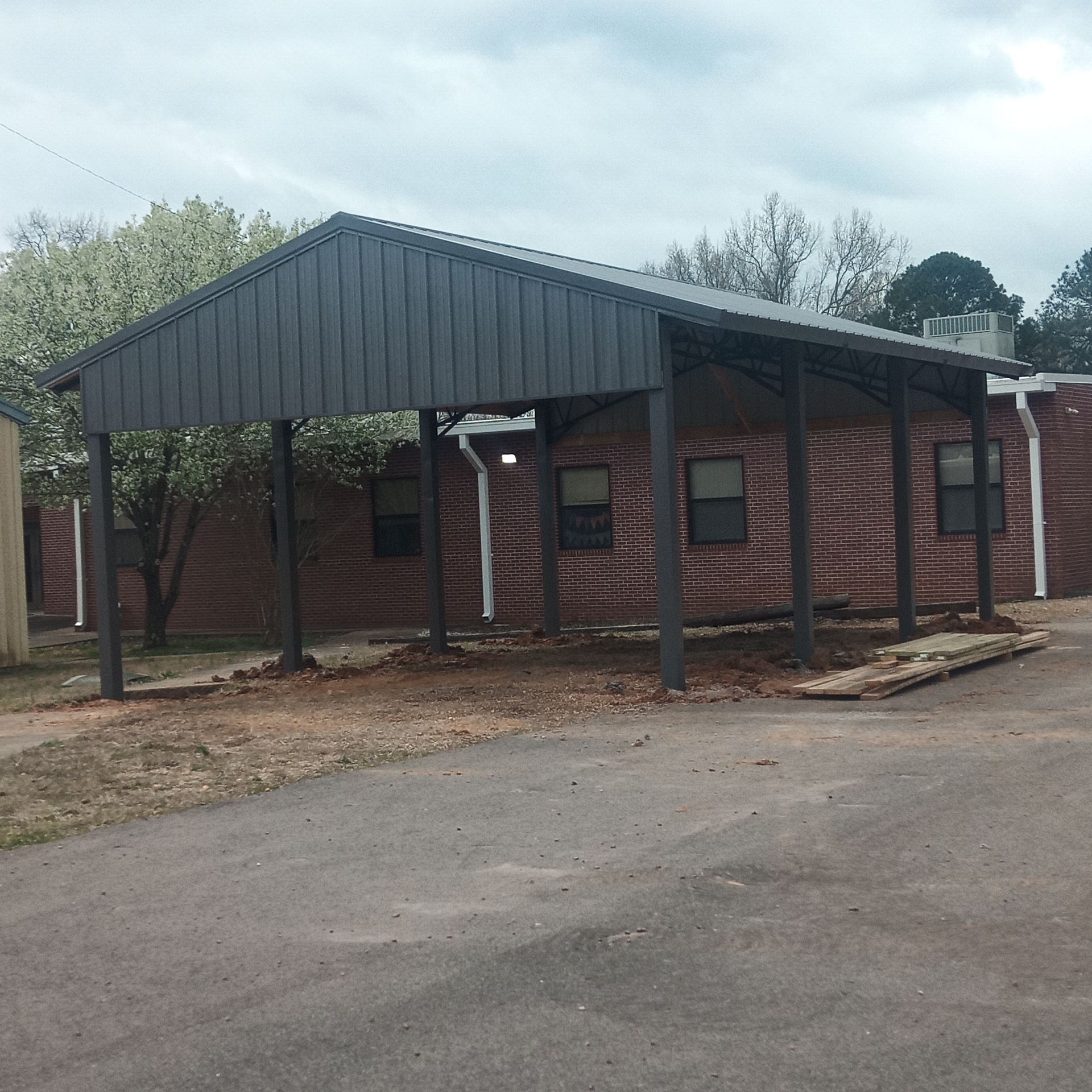 A brick building with a carport in front of it