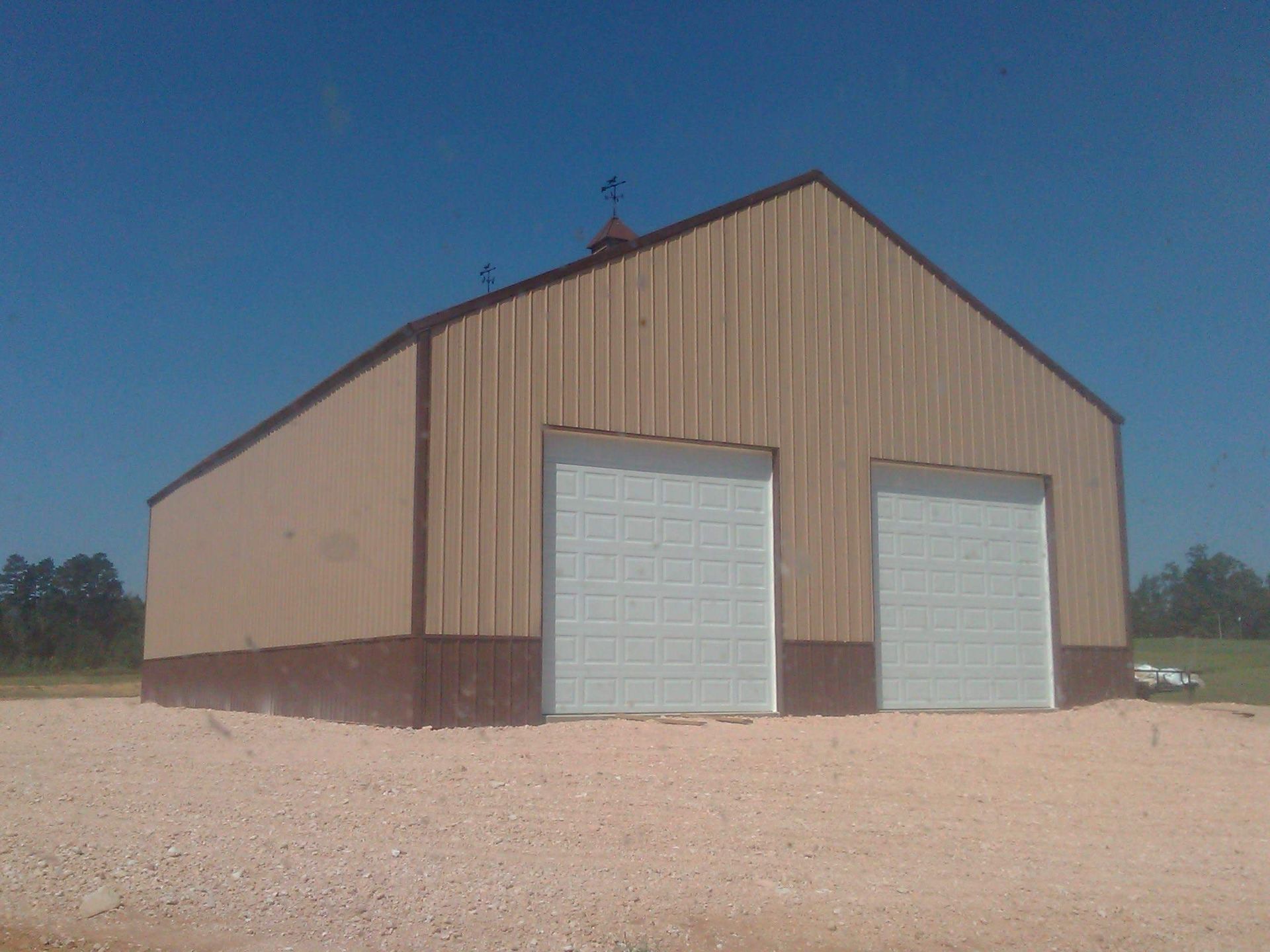 A brown building with two white garage doors