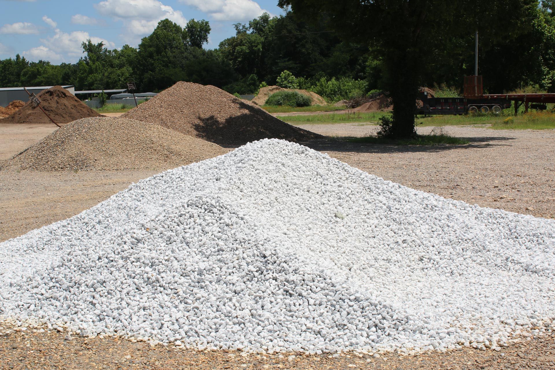 A large pile of gravel is sitting in the middle of a field.