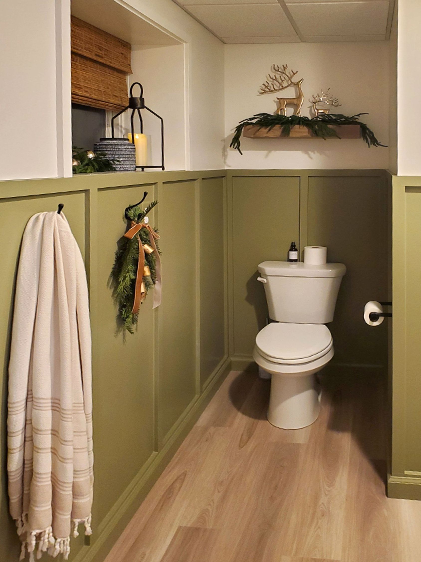 A bathroom with green walls and a toilet.