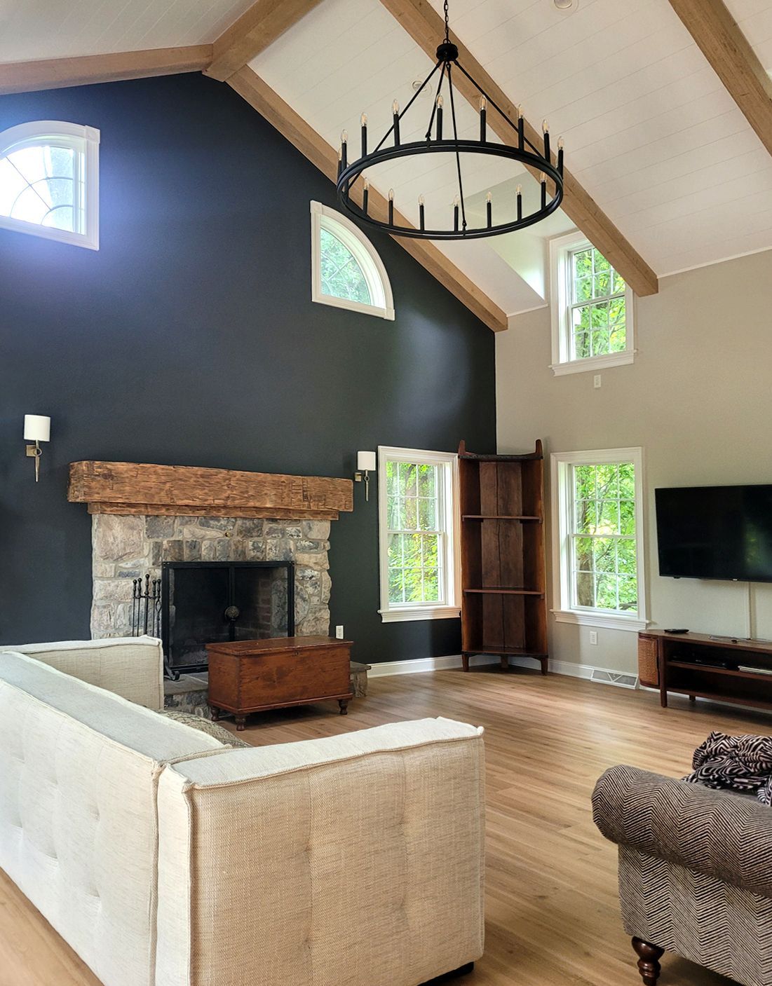 A living room with a vaulted ceiling and a fireplace