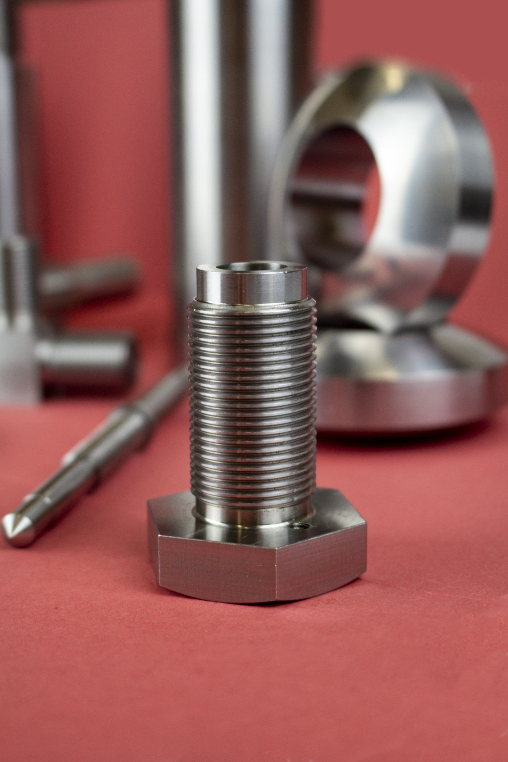 Metal bolts and fixings against a red backdrop