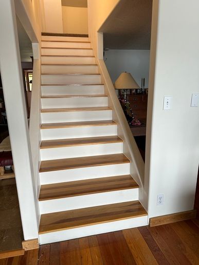 White door frame and molding against a white wall, next to a wooden floor.