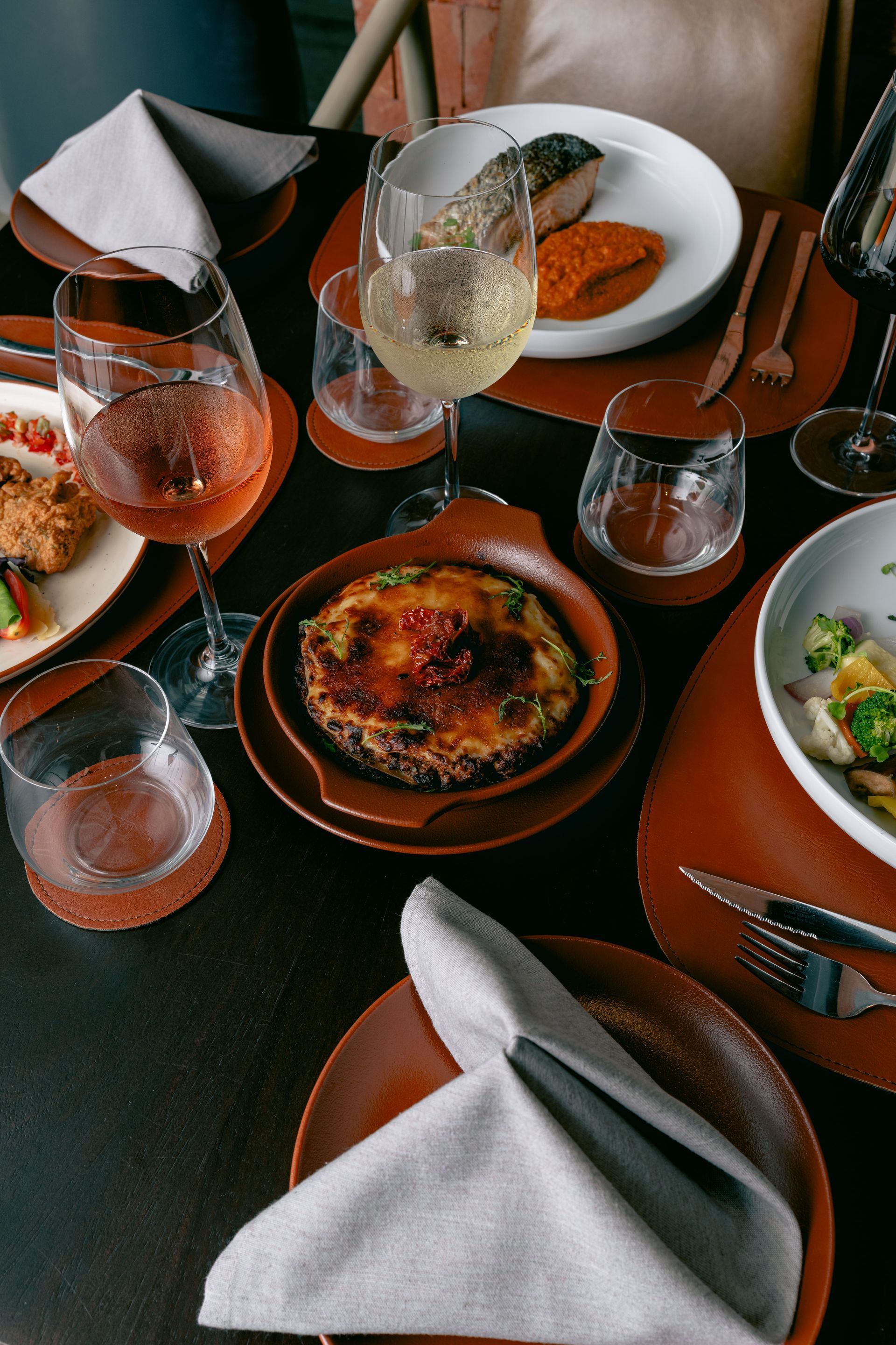 Sala de relajación spa con tumbonas, sofá, cortinas y tonos neutros.