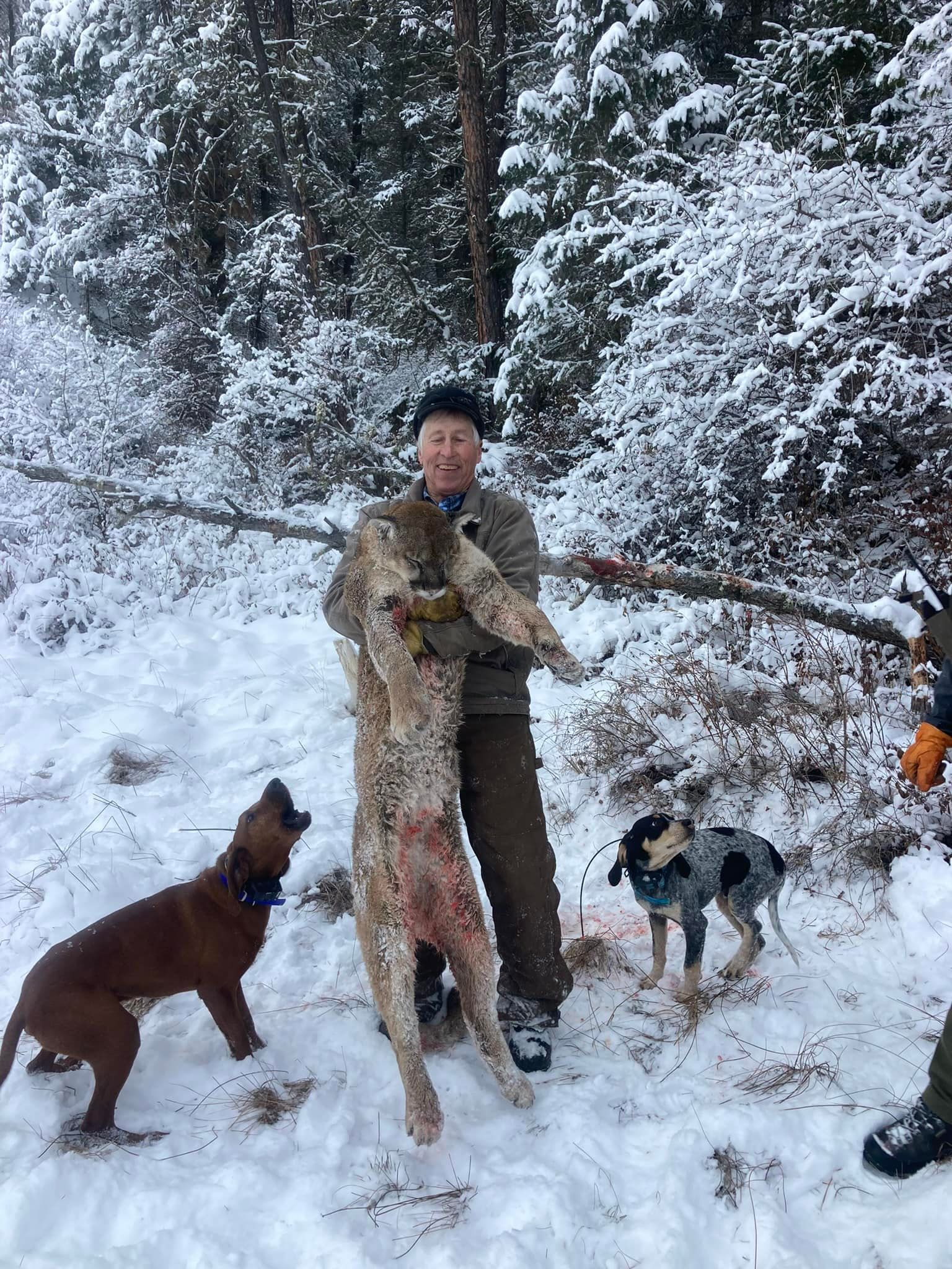 Man posing with deer in a forest