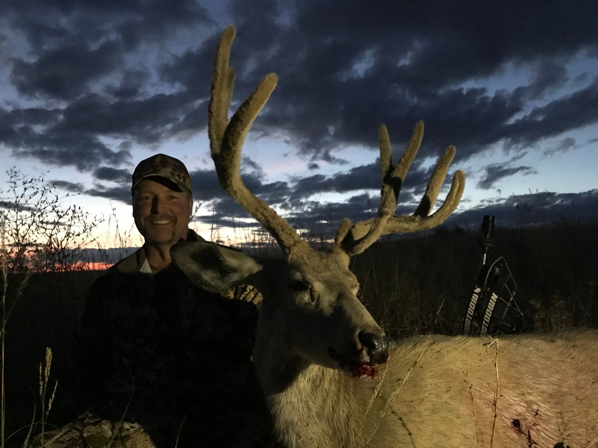 Man posing with deer in a forest