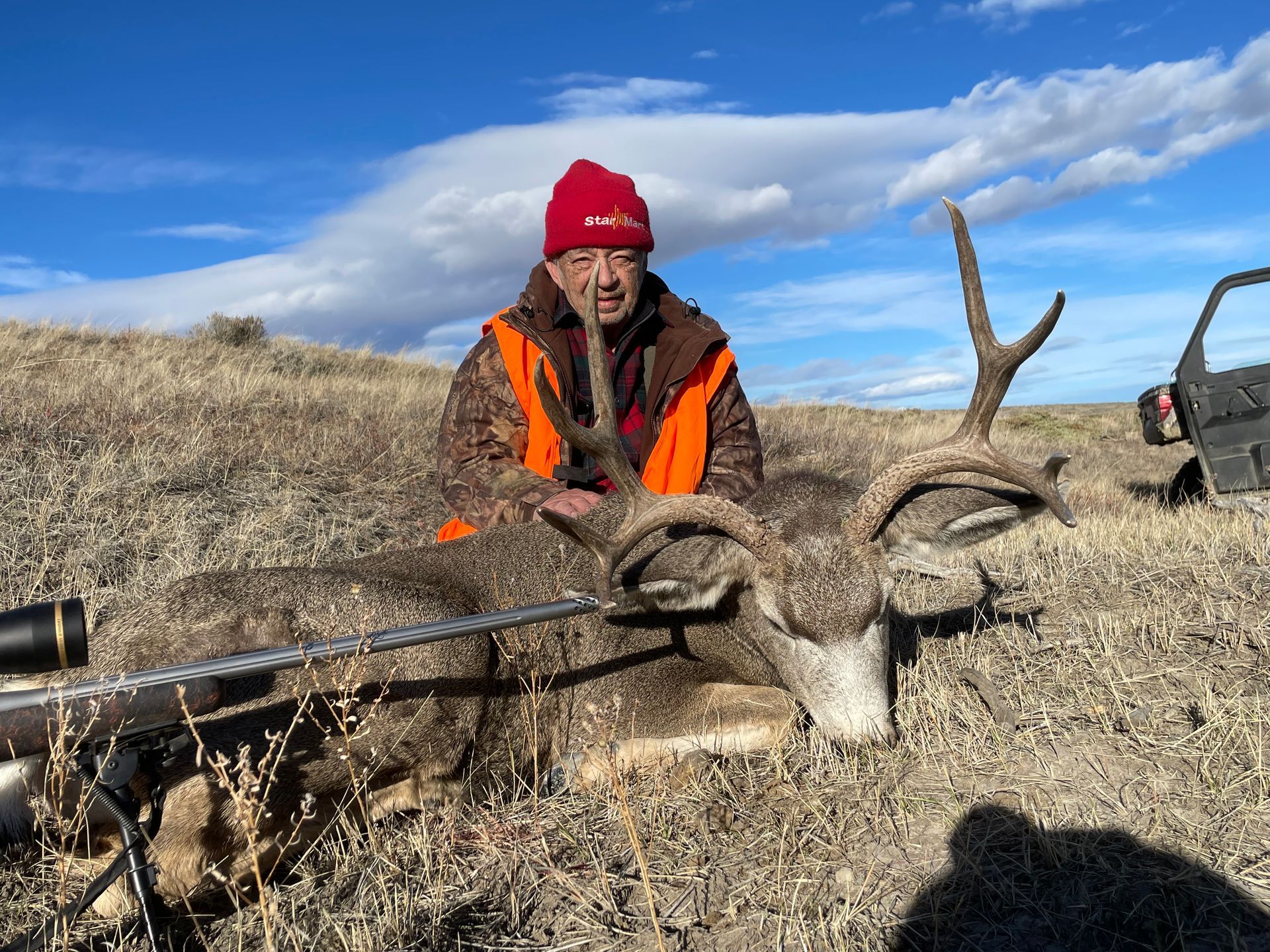 Man posing with deer in a forest
