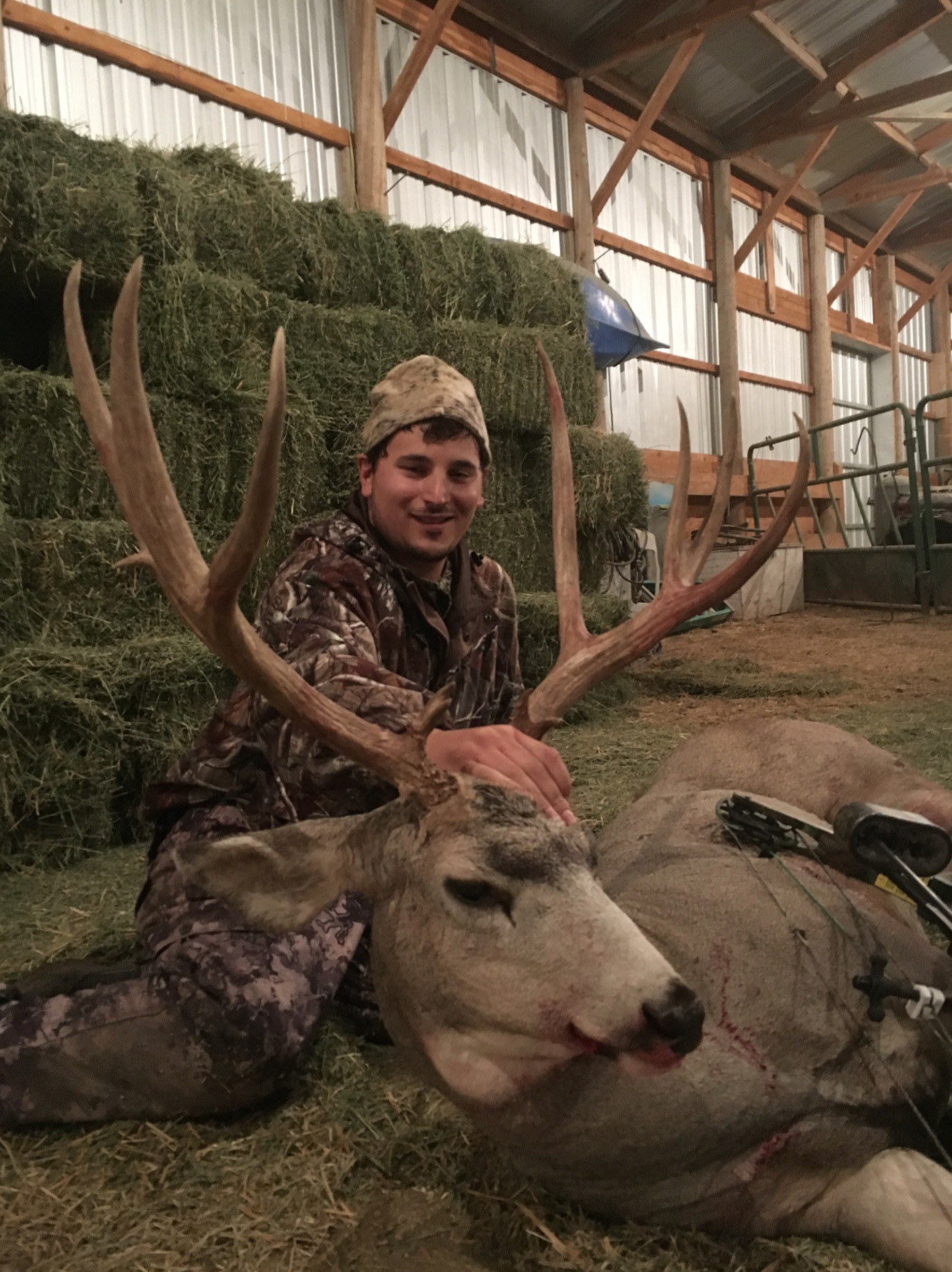 Man posing with deer in a forest