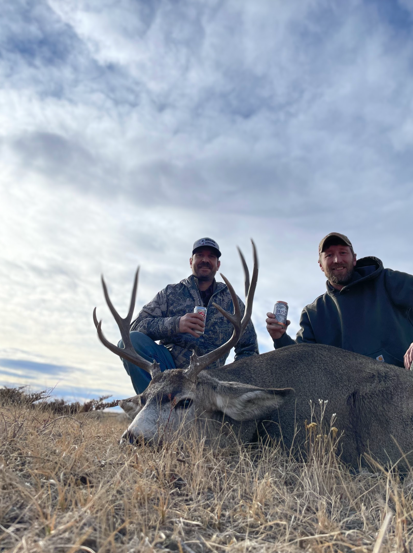 Man posing with deer in a forest