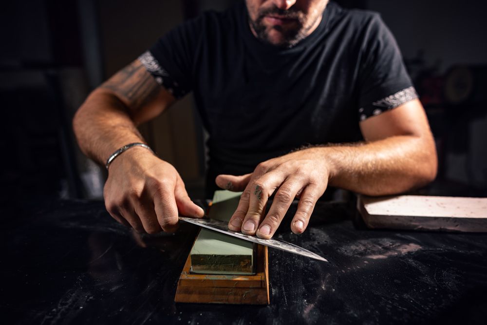 The Man Using Whetstone to Sharpening Chef Knife — Mobile Scissor Sharpening in Sunshine Coast, QLD