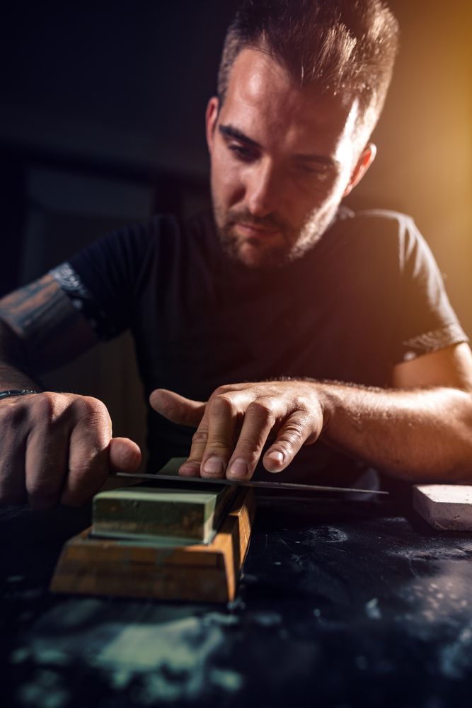 Man Sharpening Knife Using Whetstone — Mobile Scissor Sharpening in Ilkley, QLD