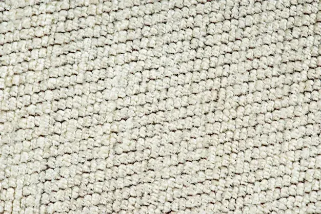 A close up of a white carpet with a pattern.