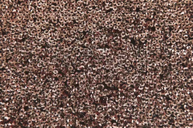 A close up of a pile of brown sequins.