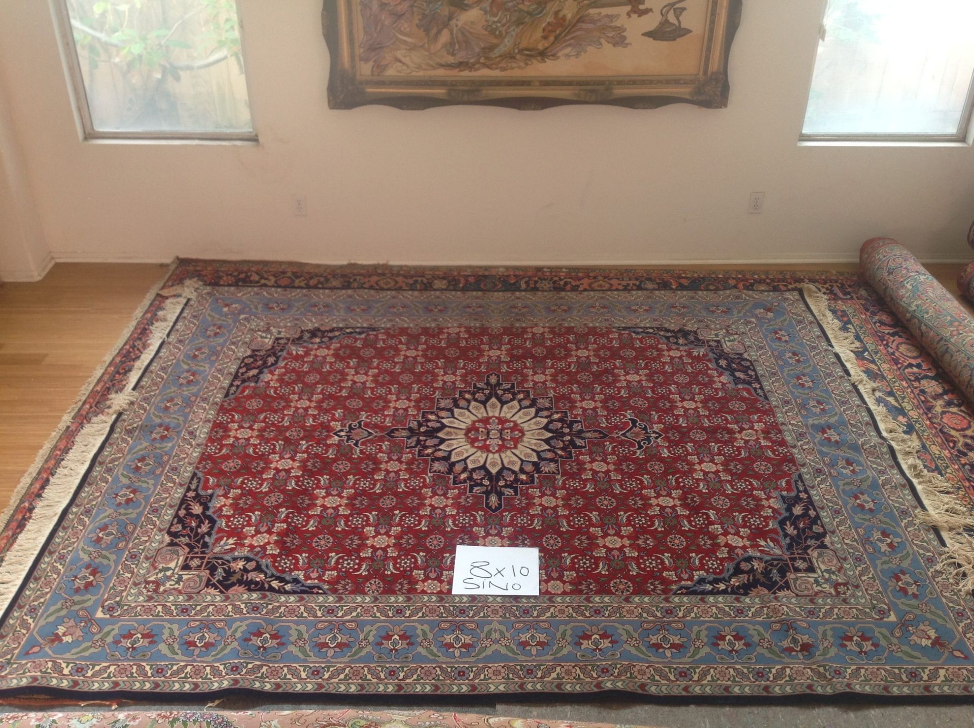 A large rug is sitting on the floor in a living room.