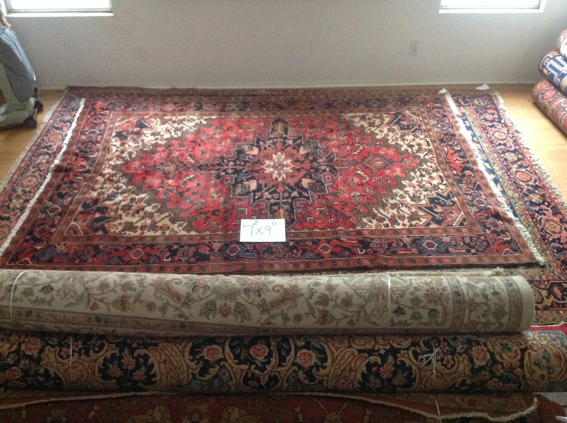 A large rug is sitting on top of a wooden floor in a room.