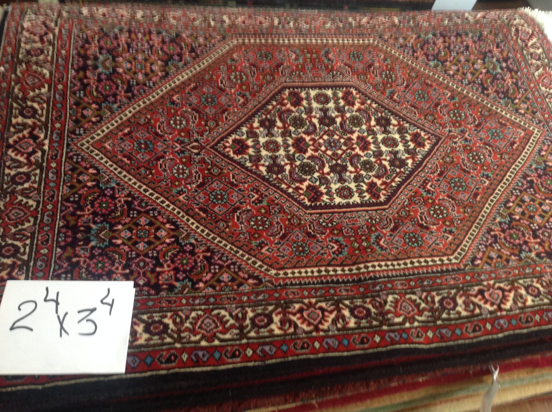 A rug with a diamond pattern and a sign that says ' x34 ' on it