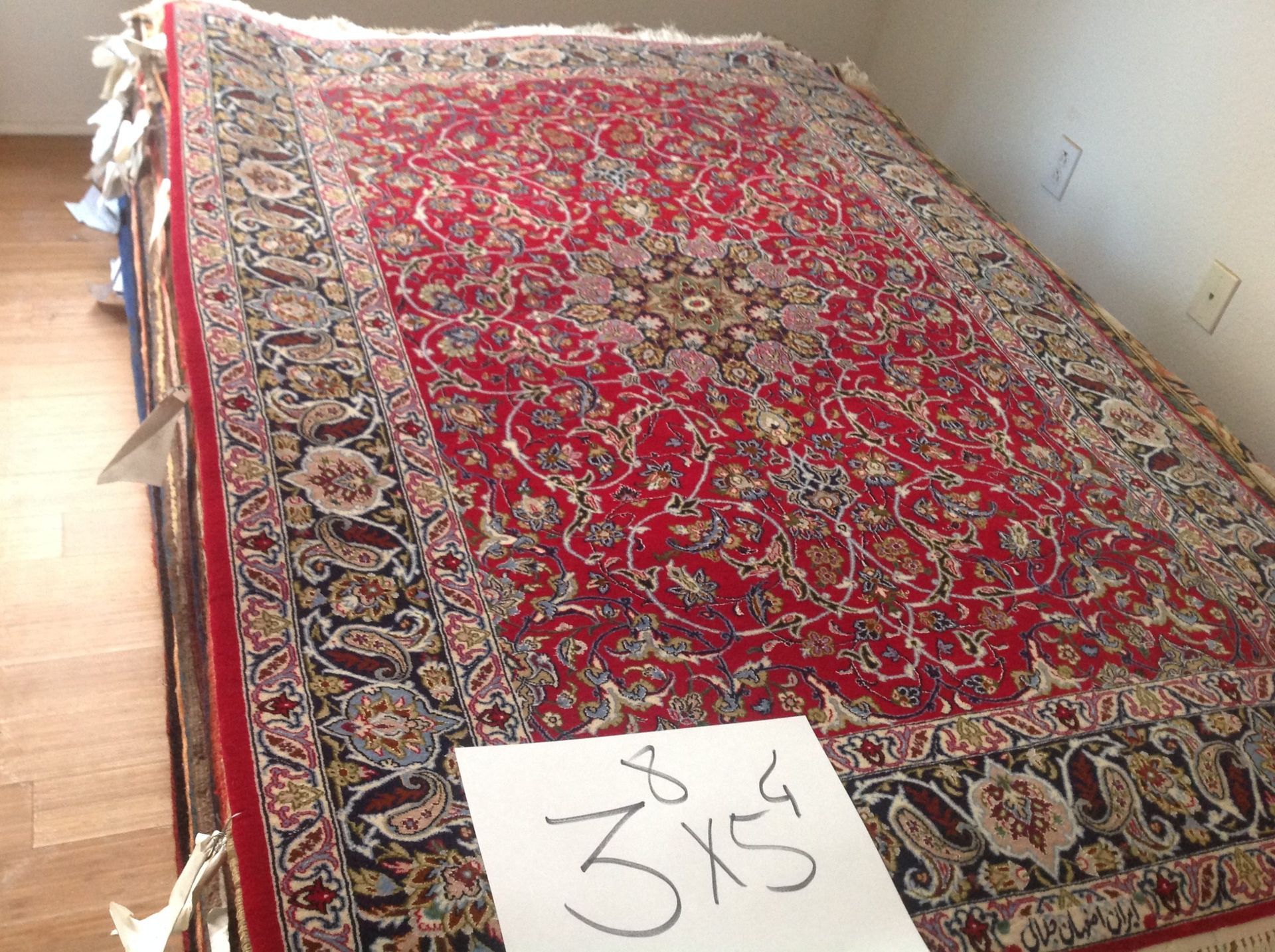 A red rug with a sign that says 3x5 on it