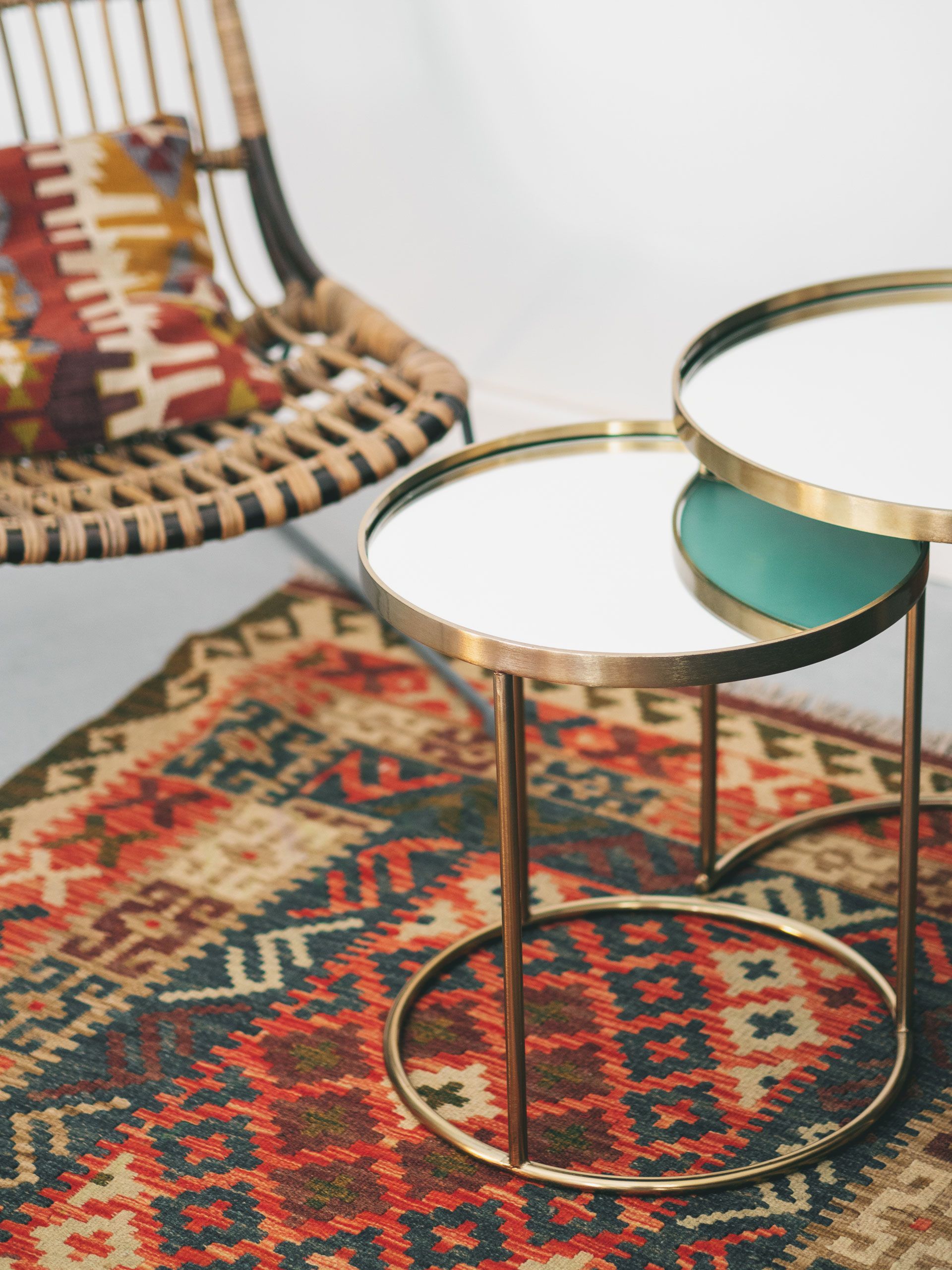 Two tables are sitting on a rug next to a chair