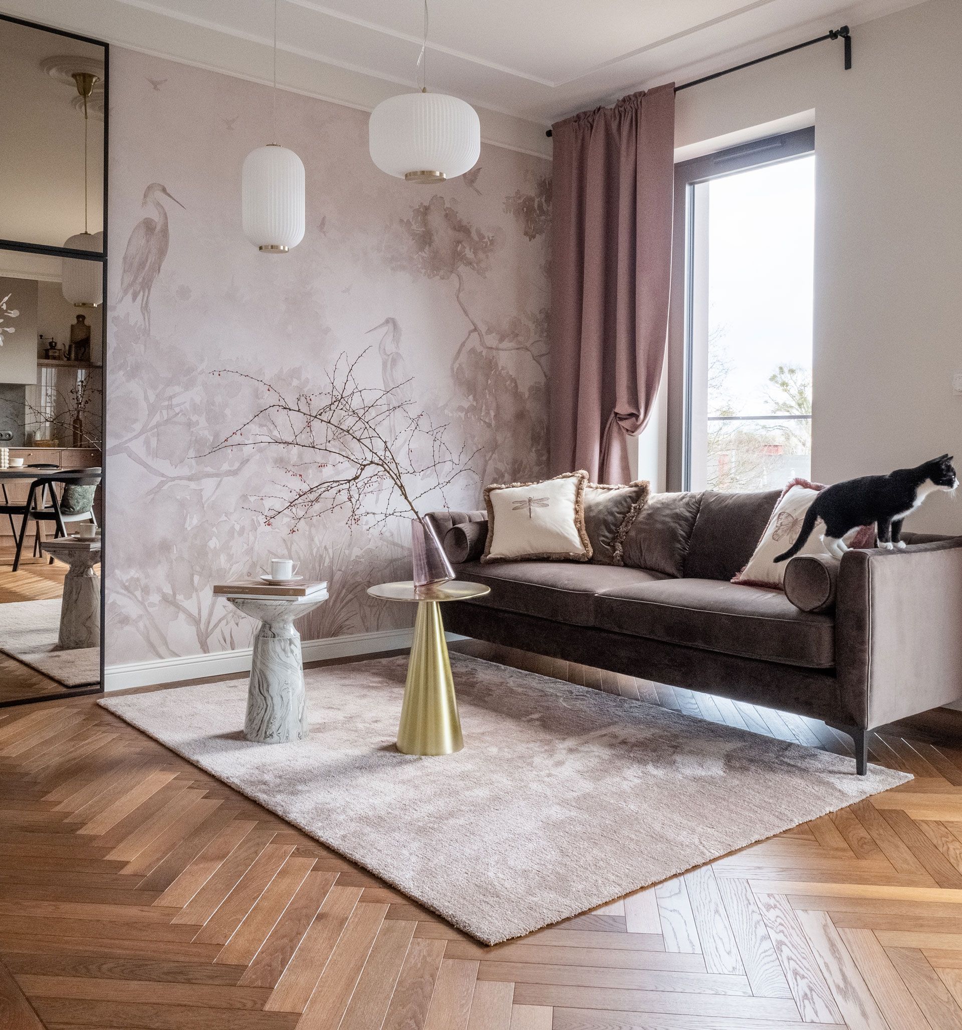 A living room with a couch and a cat on the couch.