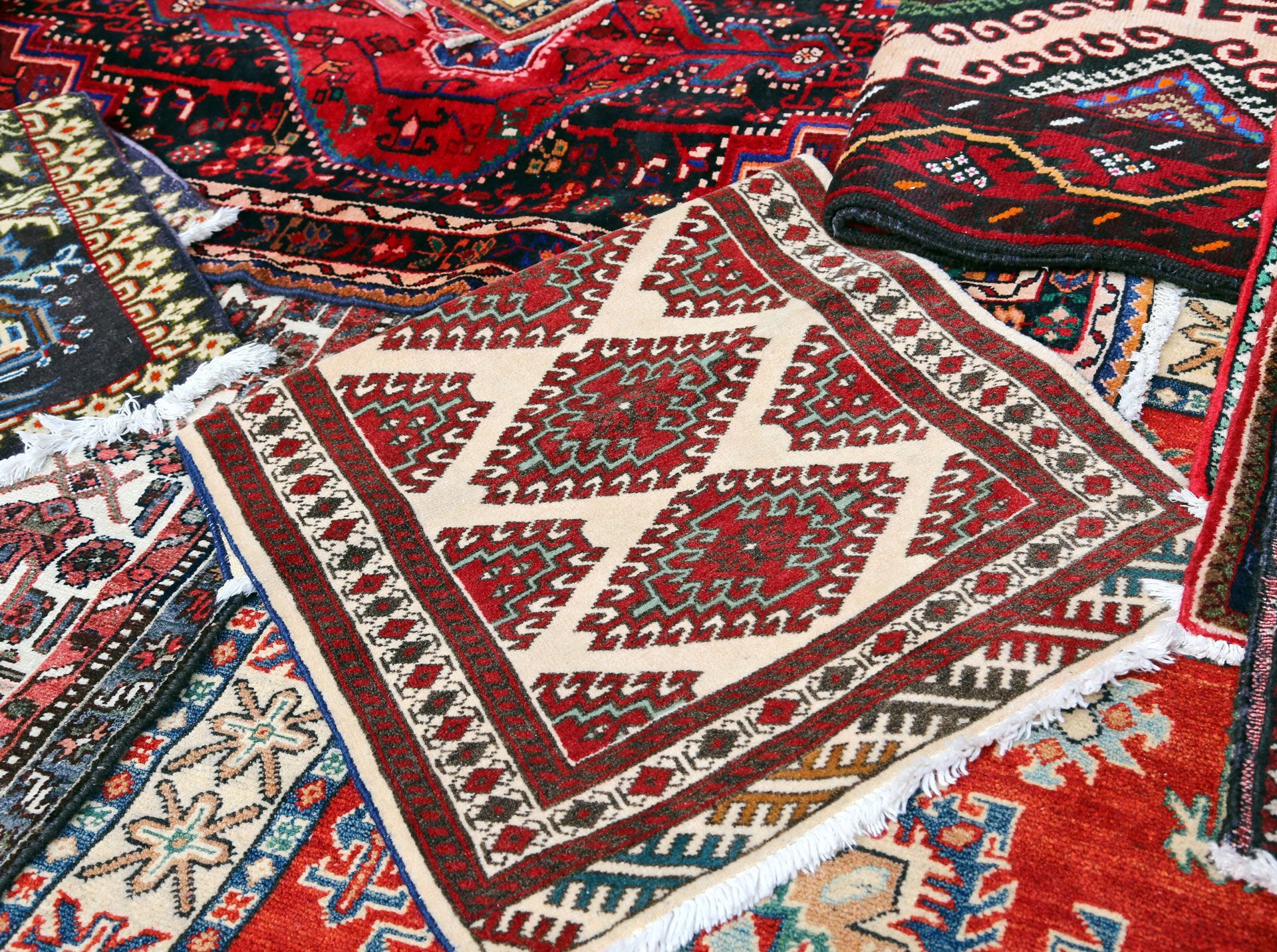 There are many different types of rugs on the floor.