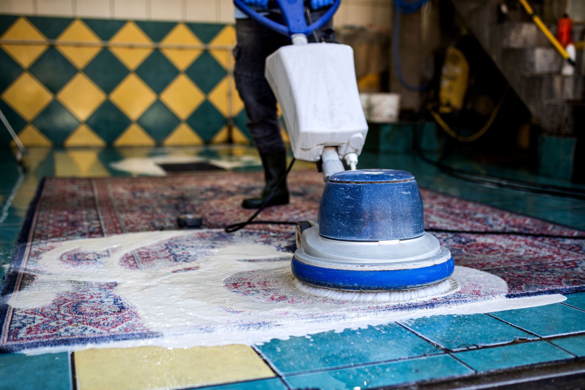A person is cleaning a rug with a machine.