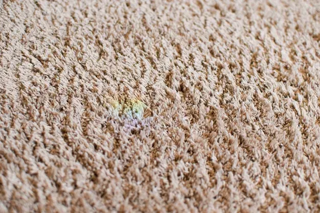 A close up of a carpet with a rainbow stain on it.