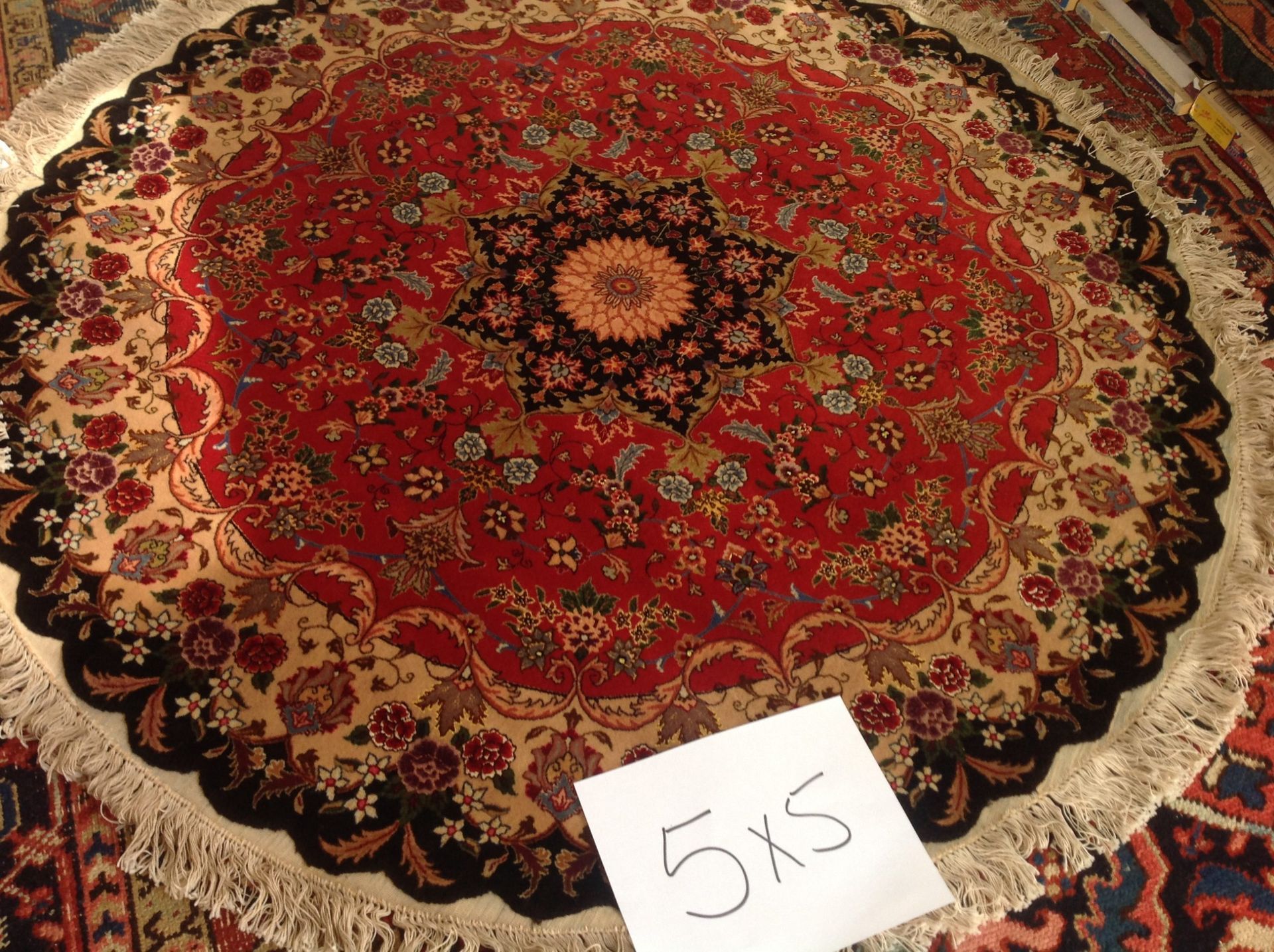 A round rug with a sign that says 5x5 on it
