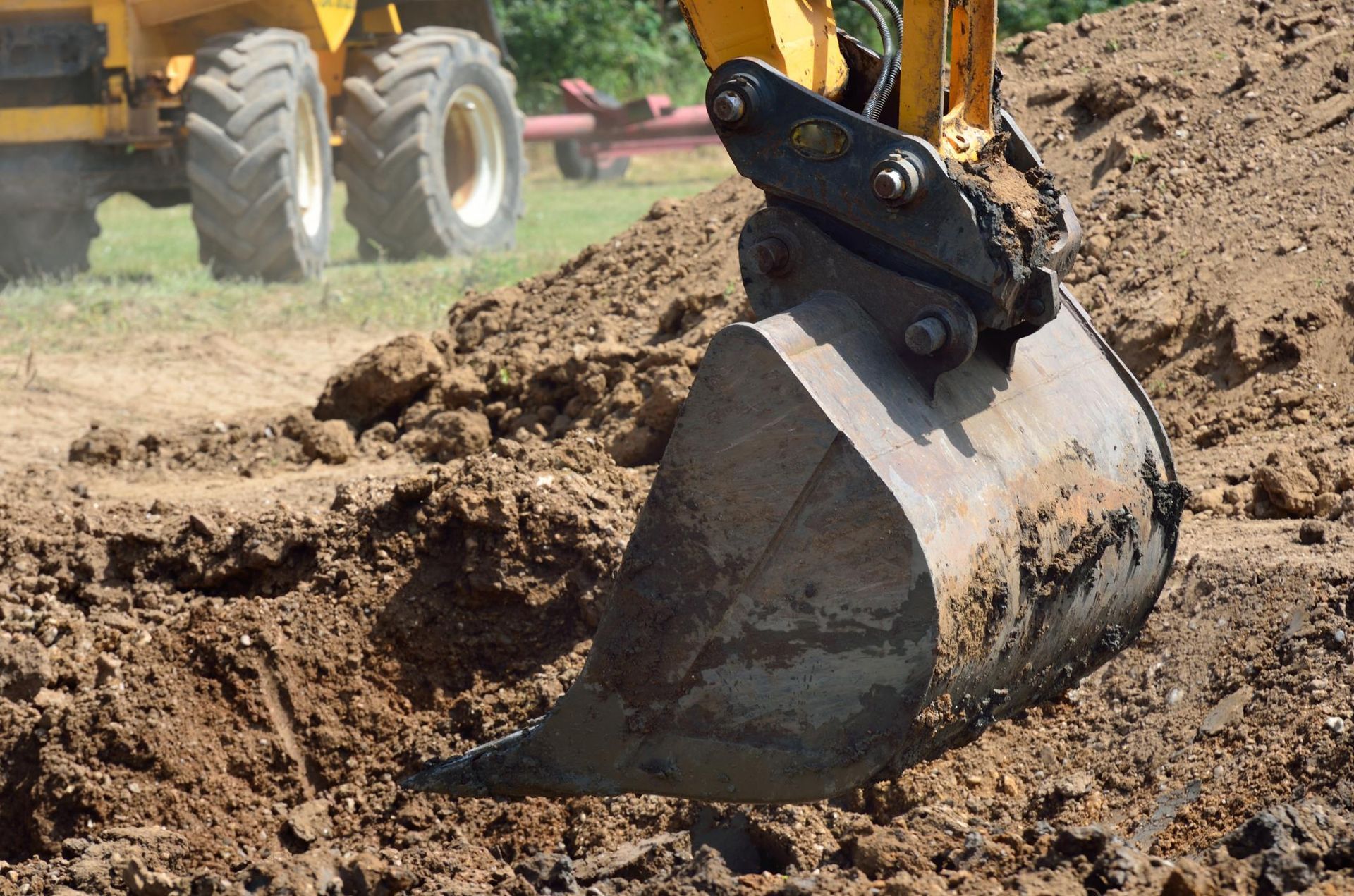 a bulldozer digging dirt in the middle of a field
