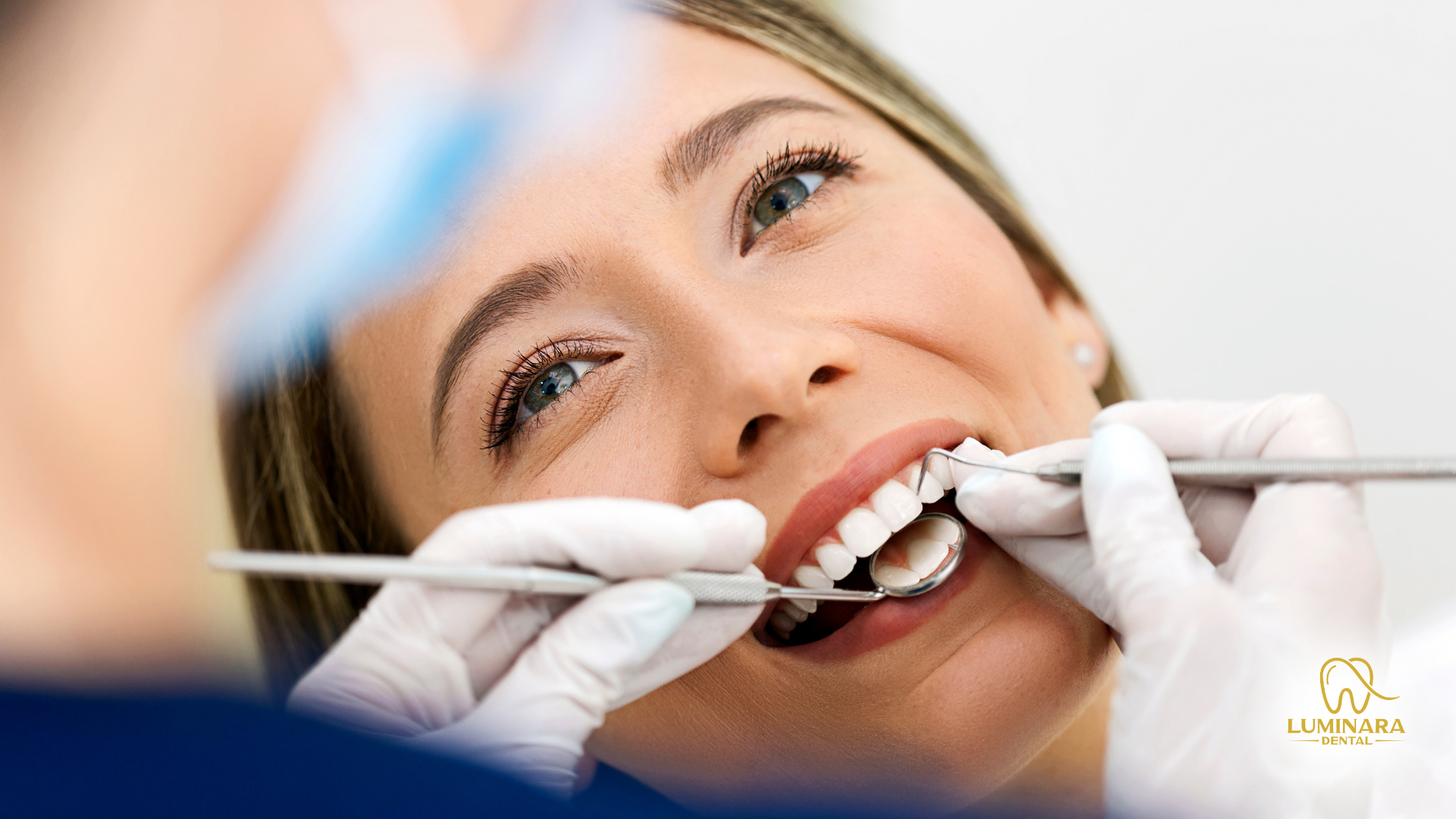 Woman at dentist, smiling, receiving oral exam with dental tools in clinic.