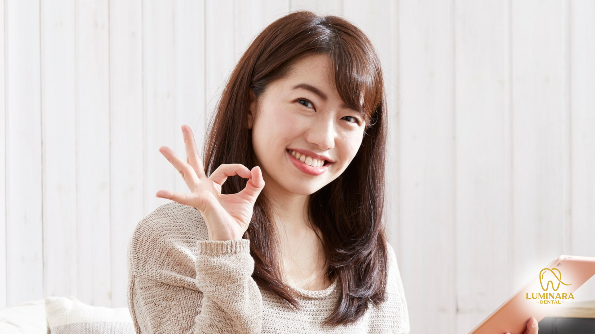Woman with dark hair smiles, giving an
