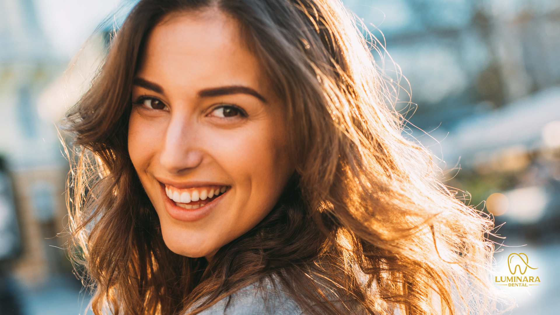 A woman with long hair is smiling and looking at the camera.