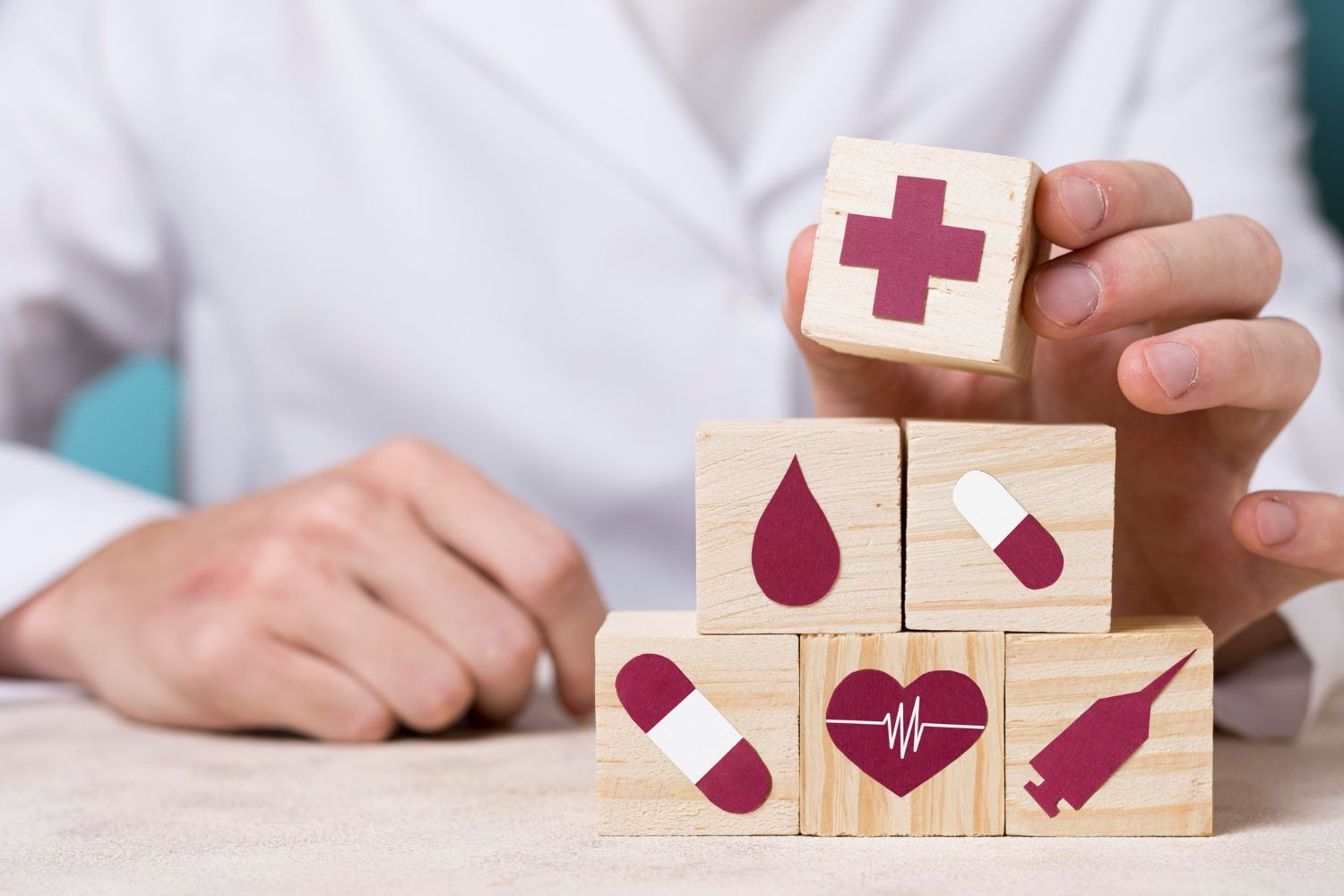 A person is holding a wooden block with a cross on it.