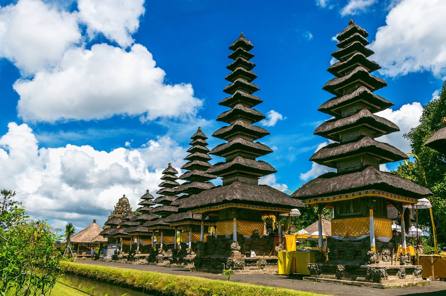 A row of temples with a blue sky and clouds in the background.