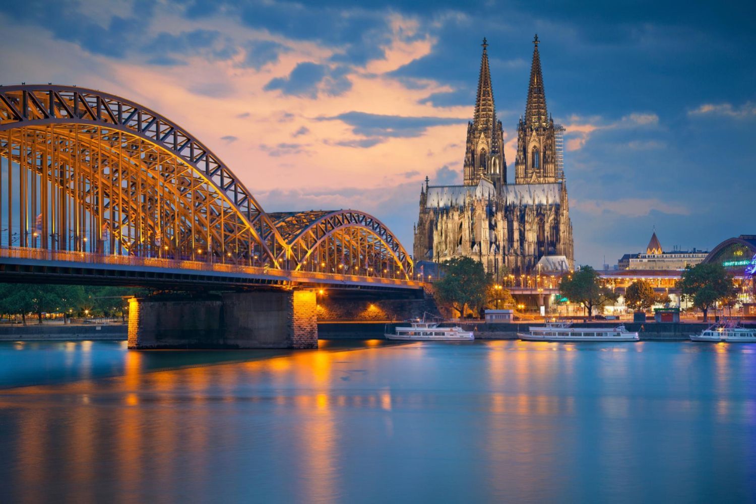 A bridge over a river with a cathedral in the background.