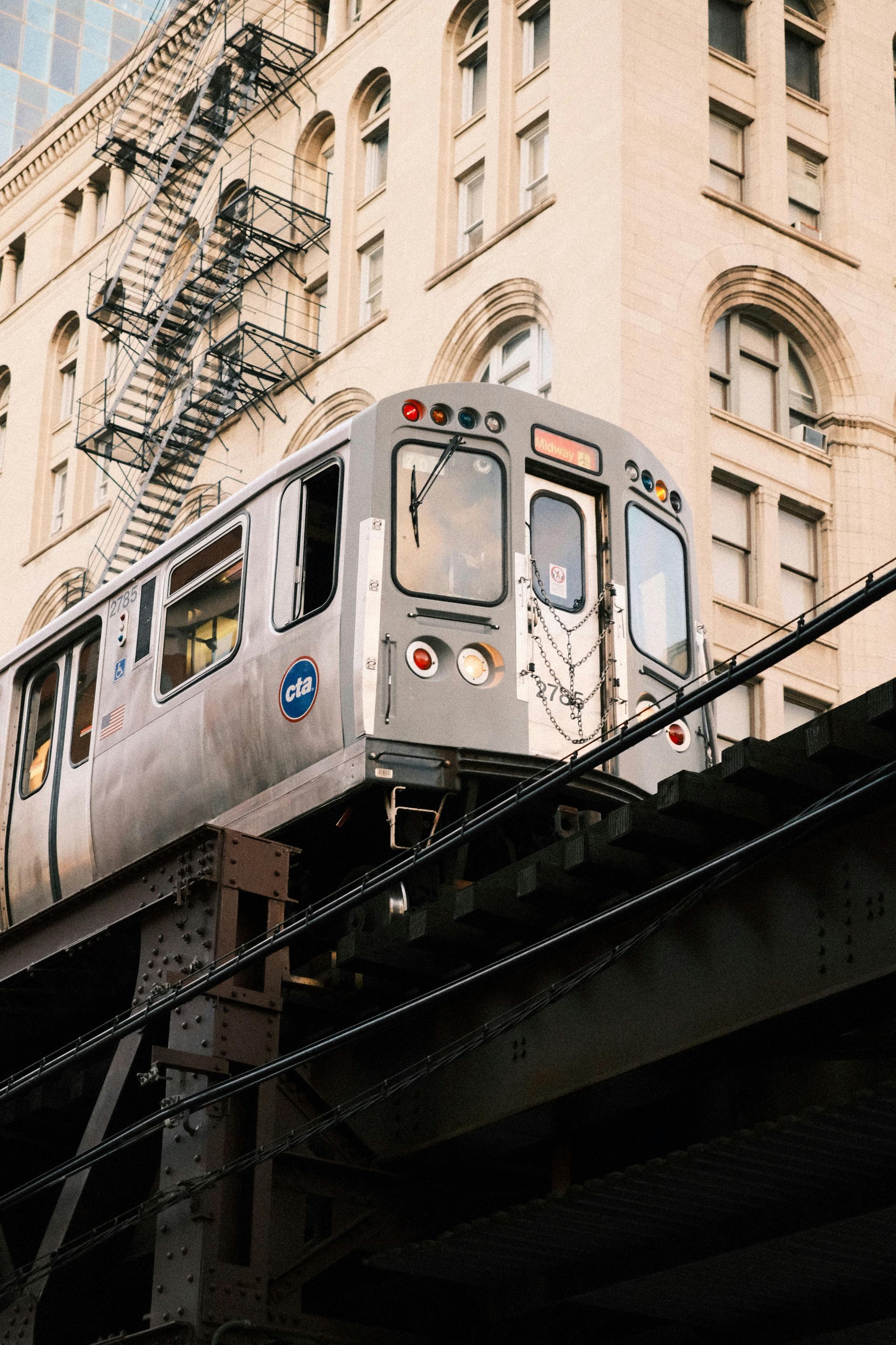 A train is going over a bridge in front of a building