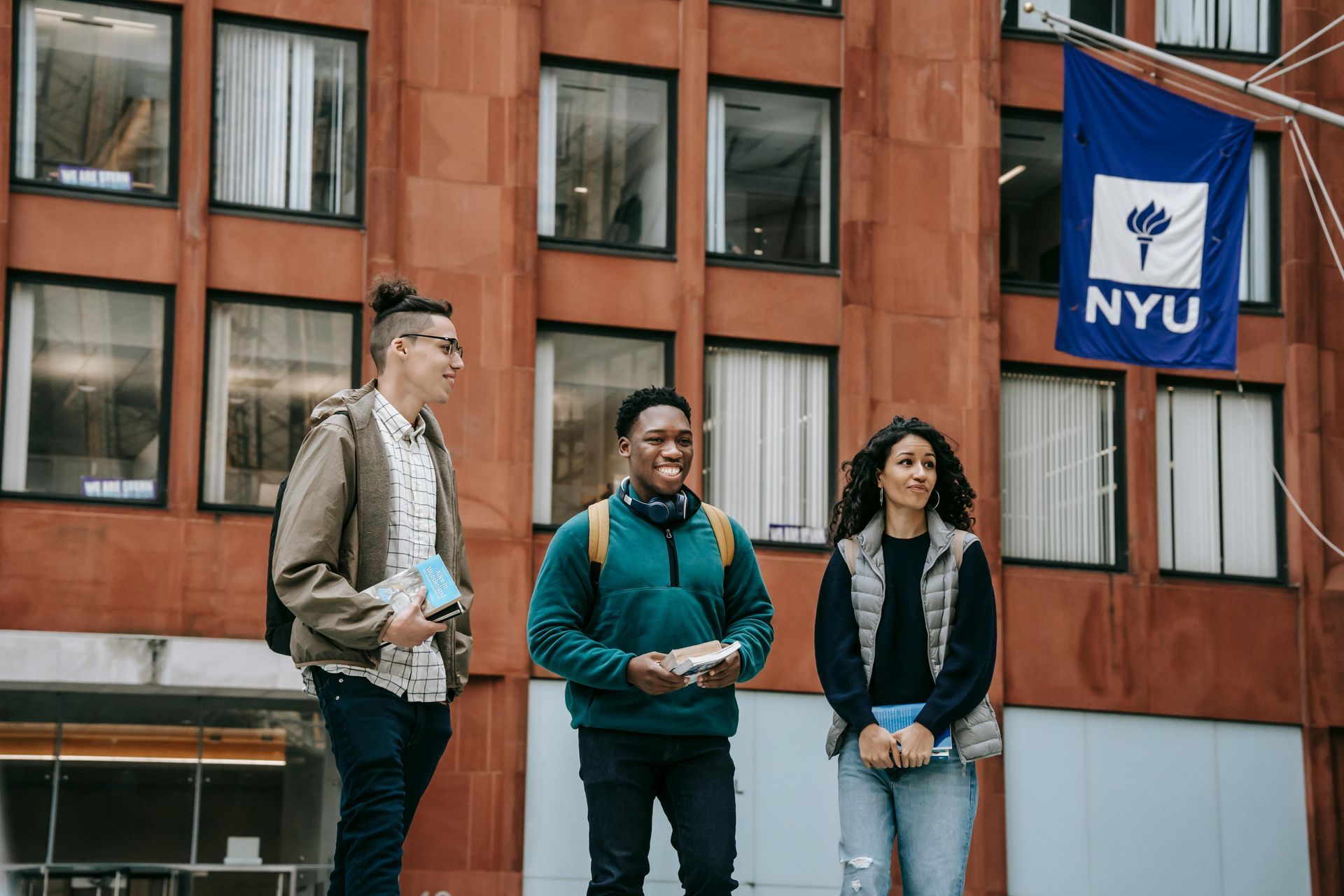 A group of students are standing in front of a nyu building.