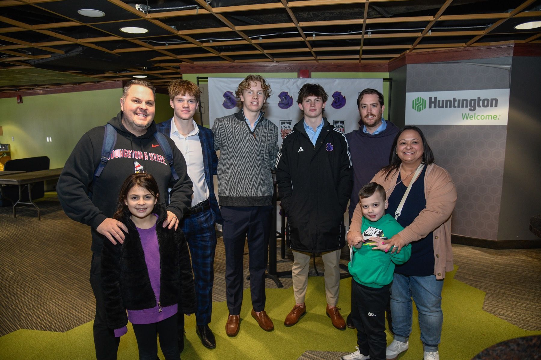 a group of baseball players and mascots are standing on a baseball field in front of a crowd .