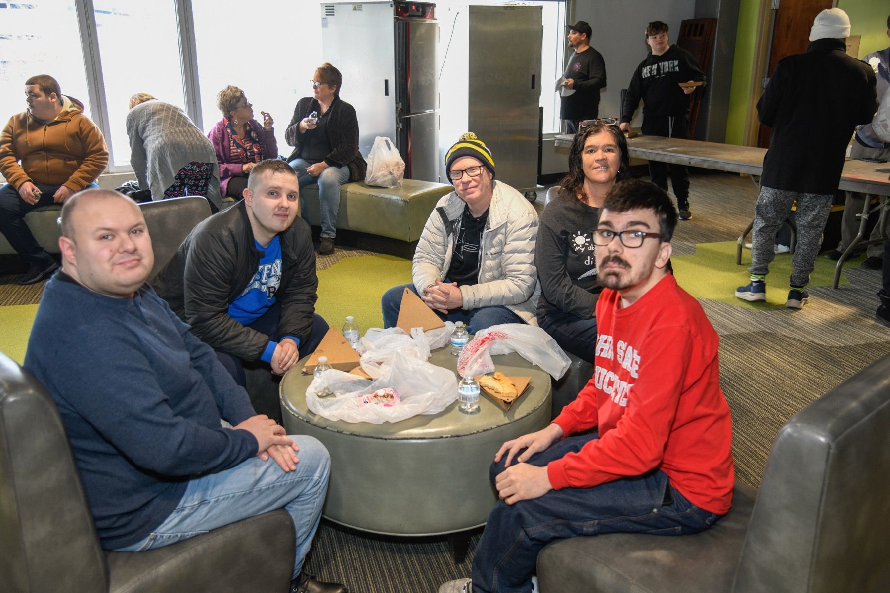 baseball players and a guest are posing for a picture on the field.